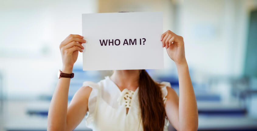 mulher segurando cartaz perguntando, "quem sou eu".
